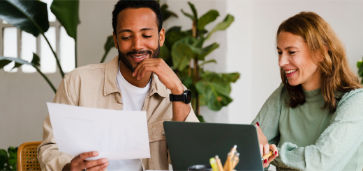 a man and a woman looking at a laptop