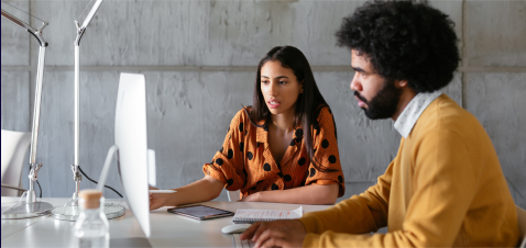 a man and a woman looking at a computer screen