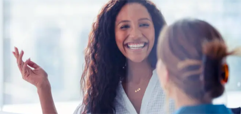 a woman smiling with her hand up