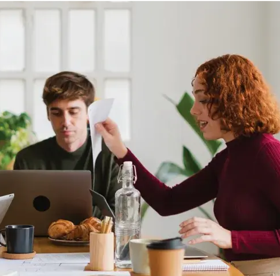 a man and a woman looking at a laptop